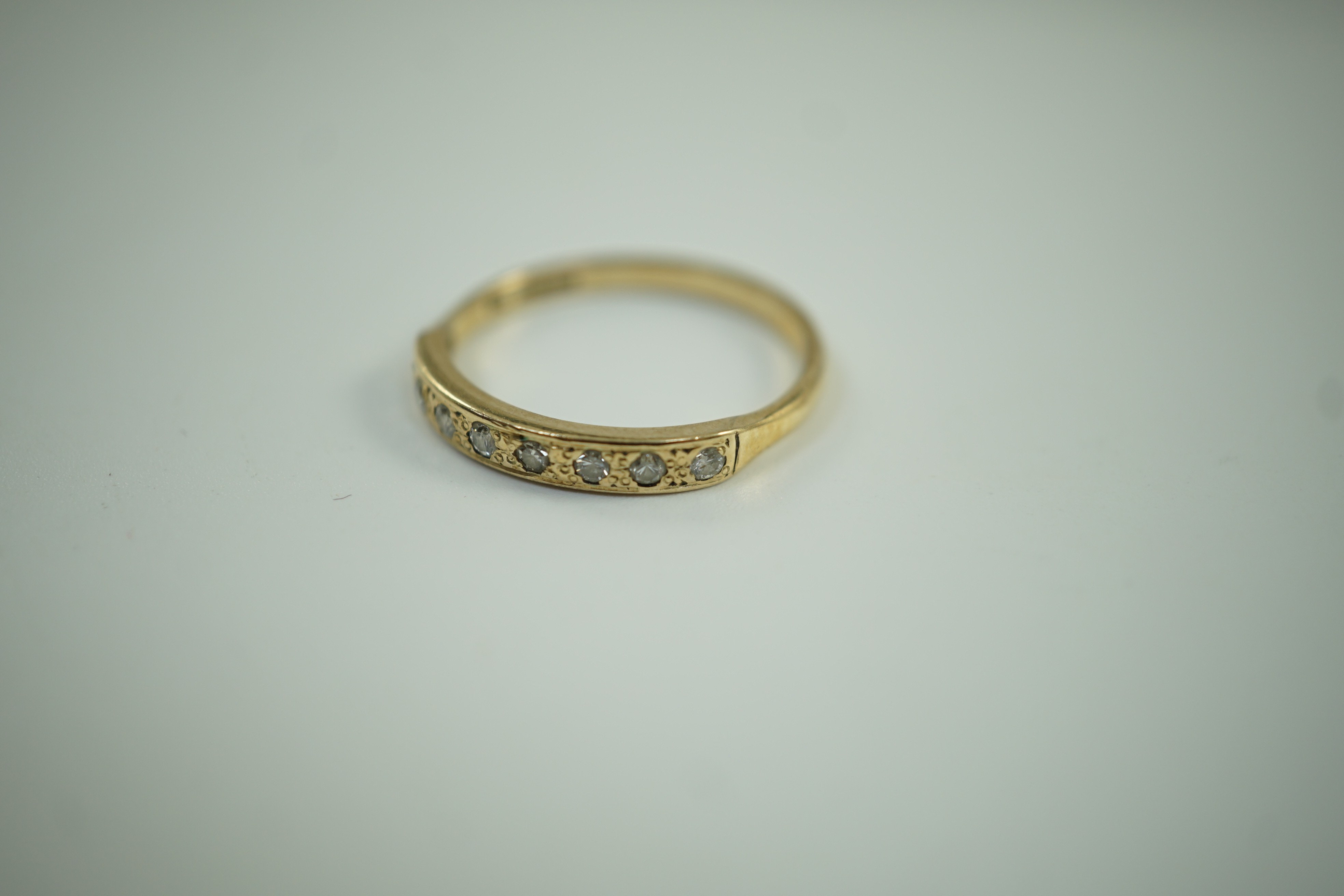 A modern 9ct gold and eight stone diamond chip set half hoop ring, size O, gross weight 1.6 grams.